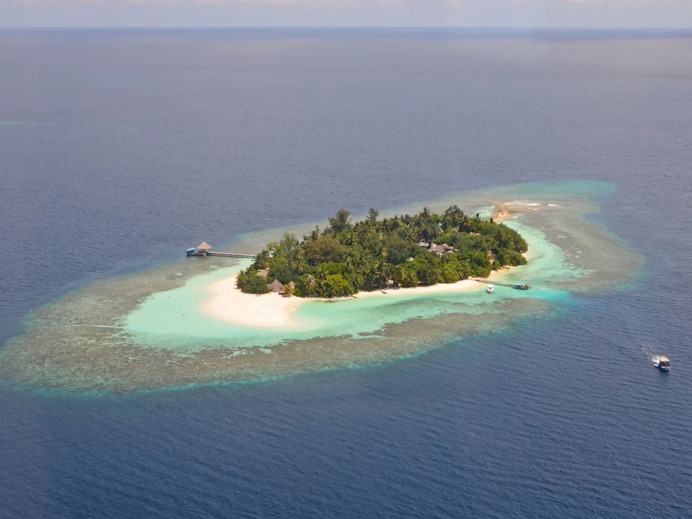 Small tropical island surrounded by a coral reef and open ocean